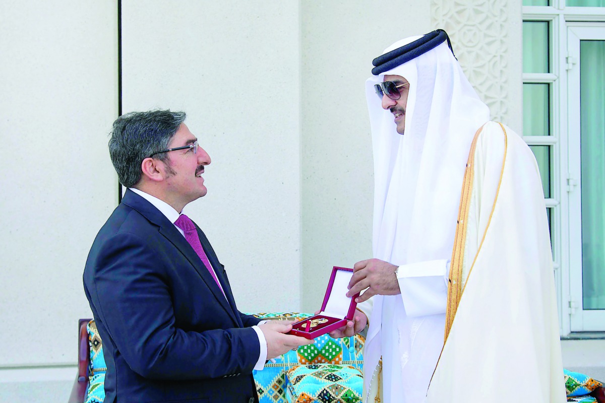 Emir H H Sheikh Tamim bin Hamad Al Thani conferring Decoration of Al Wajbah to the outgoing Turkish Ambassdor Ahmet Demirok, at the Emiri Diwan yesterday.