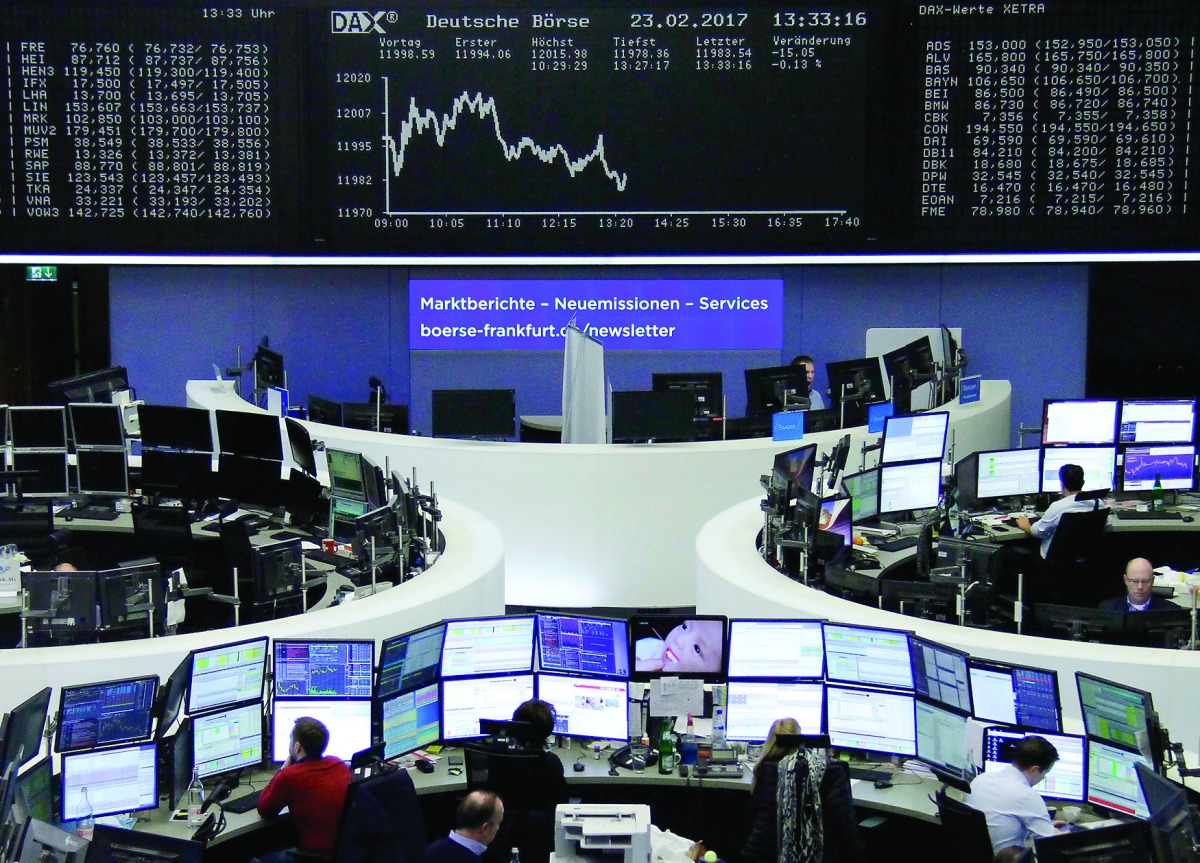 Traders work at their desks in front of the German share price index DAX board in Frankfurt?
