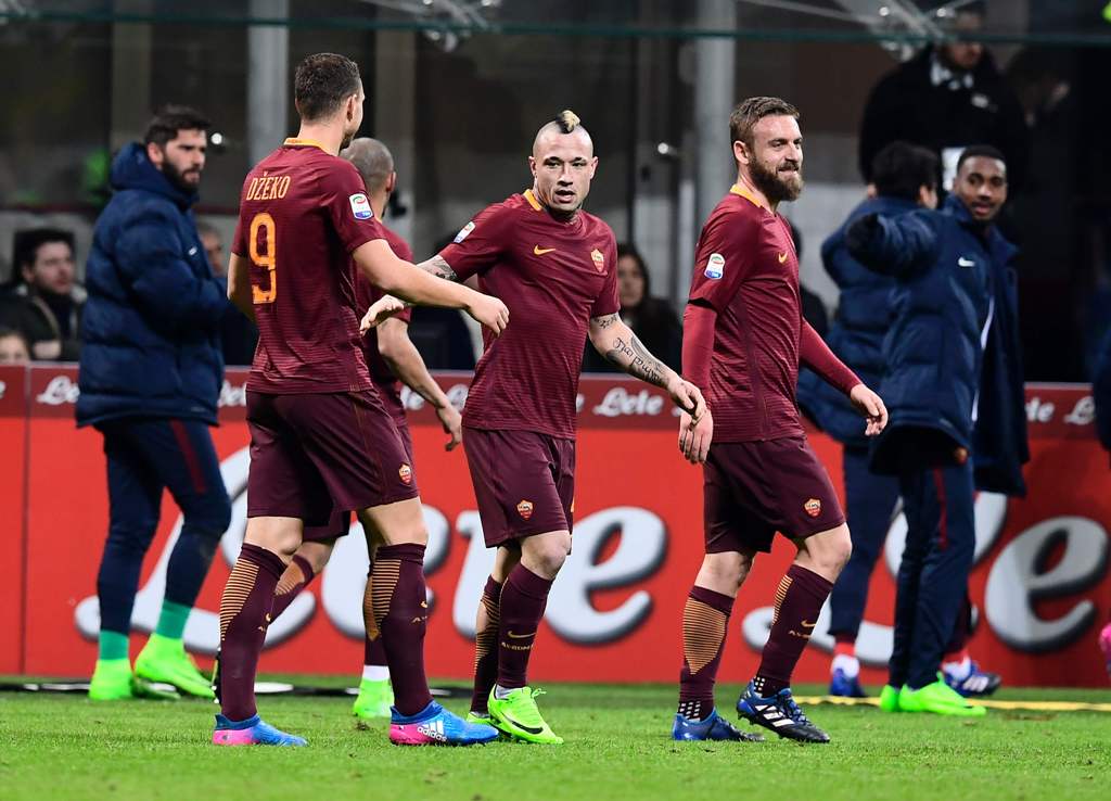 AS Roma's Belgium midfielder Radja Nainggolan (C) is congratulated by teammates after scoring his second goal during the Italian Serie A football match Inter Milan vs AS Roma at the San Siro stadium in Milan on February 26, 2017. / AFP / MIGUEL MEDINA
