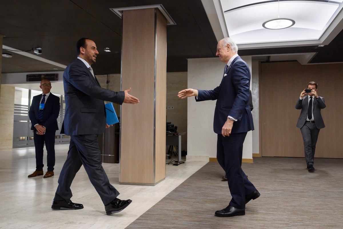 UN Special Envoy for Syria Staffan de Mistura (R) shakes hands to Syria's main opposition High Negotiations Committee (HNC) leader Nasr al-Hariri upon his arrival for a meeting on February 27, 2017 in Geneva. A ban on mobile phones, recording devices and 