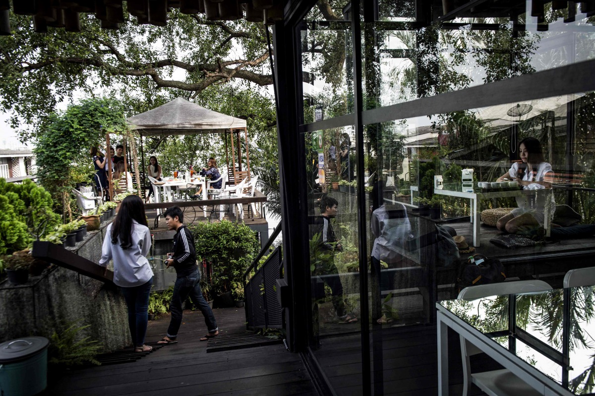 This picture taken on November 4, 2016 shows people relaxing at the eco-friendly Bangkok Treehouse hotel in Bang Krachao, the so-called 