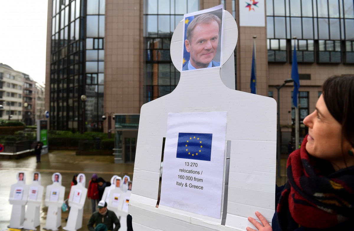 An activist stand near an effigy of European Council President Donald Tusk during a protest calling for migrants' rights as European foreign and defence ministers hold a foreign affairs and defence council at the European Council, in Brussels, on March 6,