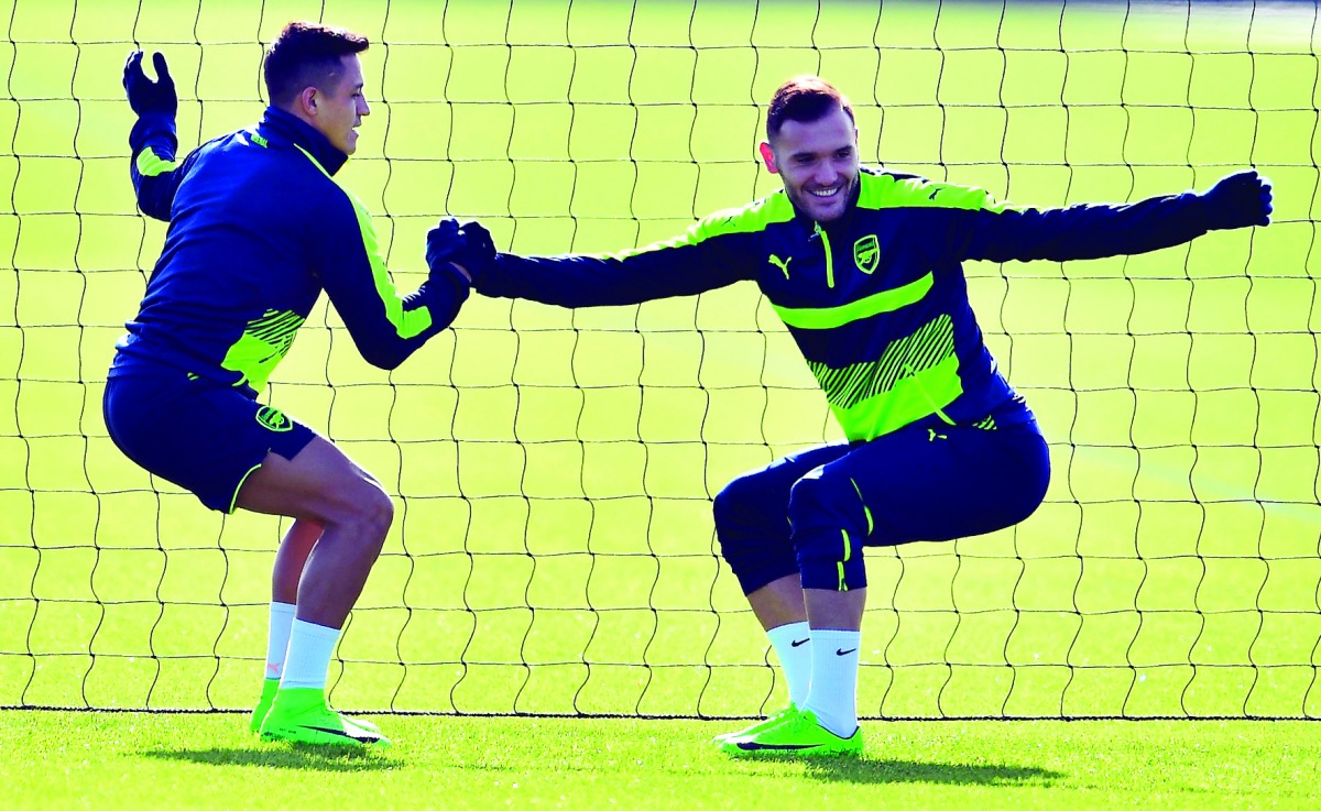 Arsenal striker Alexis Sanchez (left) and team-mater Lucas Perez are seen during a training session ahead of their UEFA Champions League round of 16 second leg match against Bayern Munich at Arsenal's London Colney training ground yesterday.