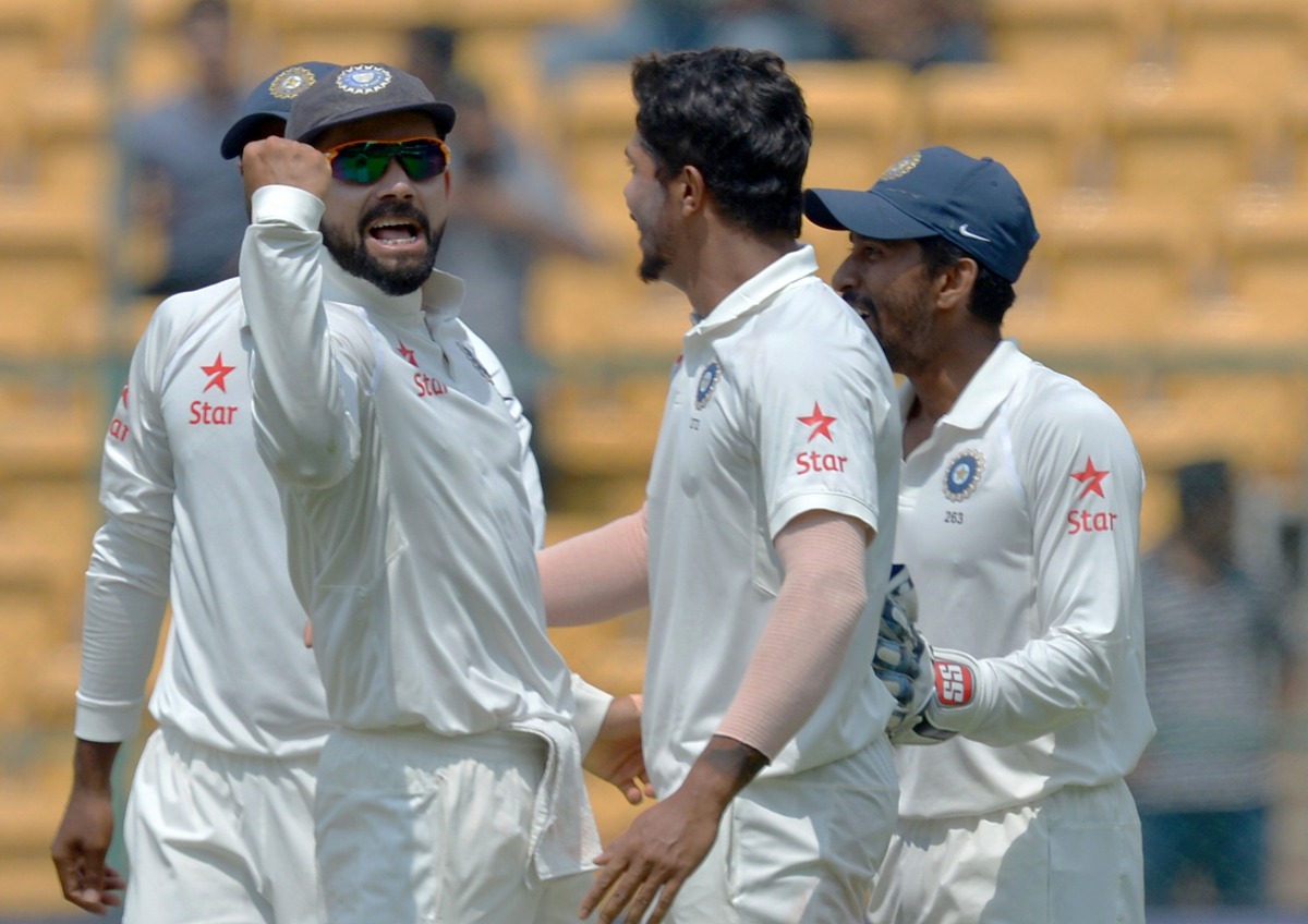 This file photograph taken on March 7, 2017, shows Indian cricket captain Virat Kohli (L) as he celebrates with bowler Umesh Yadav (C) and other teammates after the dismissal of unseen Australian captain Steve Smith during the fourth day of the second Tes