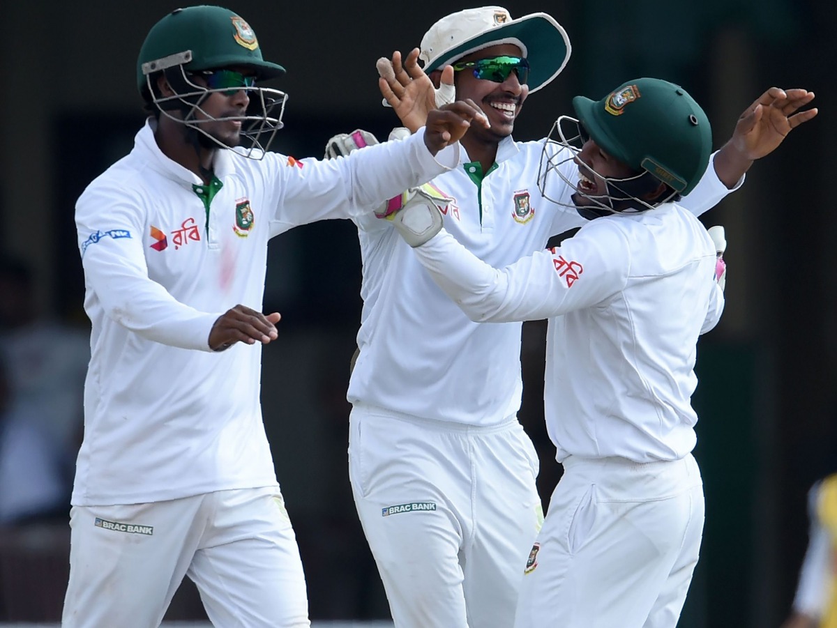 Bangladesh cricketer Soumya Sarkar (C) celebrates with teammates including captain Mushfiqur Rahim (R) after he dismissed unseen Sri Lankan cricketer Dimuth Karunaratne during the fourth day of the second and final Test cricket match between Sri Lanka and