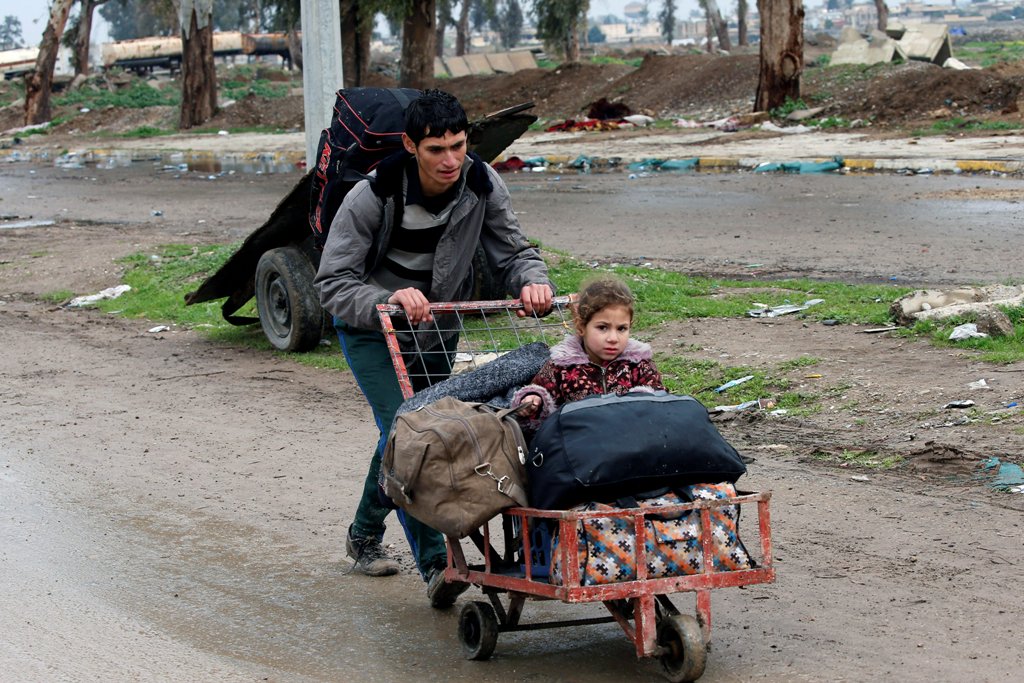 A displaced Iraqi carries his daughter in a cart to reach a safe area, as Iraqi forces battle with Islamic State militants, in the city of Mosul, Iraq March 18, 2017. REUTERS/Youssef Boudlal
