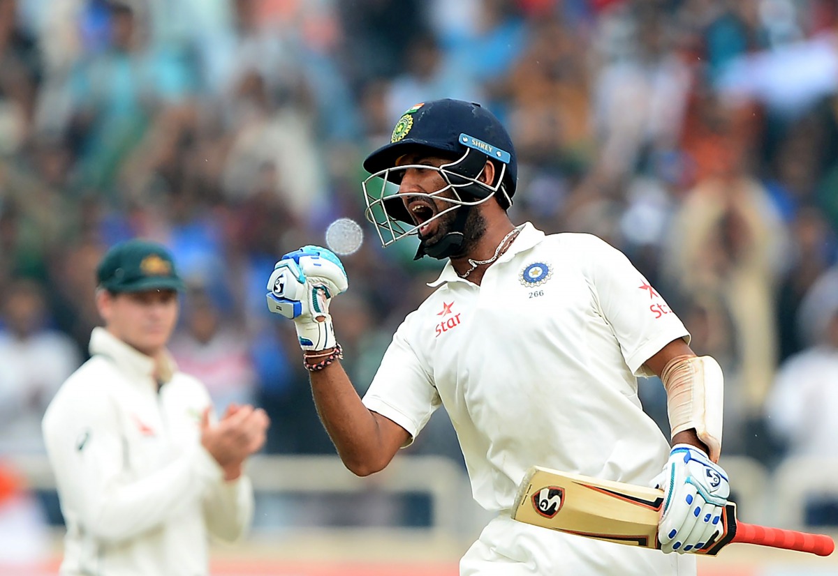 India's batsman Cheteshwar Pujara (R) is applauded by Australia's captian Steve Smith as celebrates after scoring a double century (200 runs) during the fourth day of the third Test cricket match between India and Australia at The Jharkhand State Cricket 