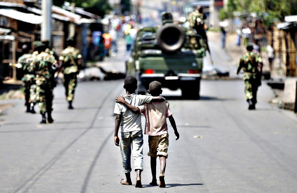 A 2015 file picture of boys walking behind patrolling soldiers in Bujumbura, Burundi. Burundian. Goran Tomasevic/Reuters
