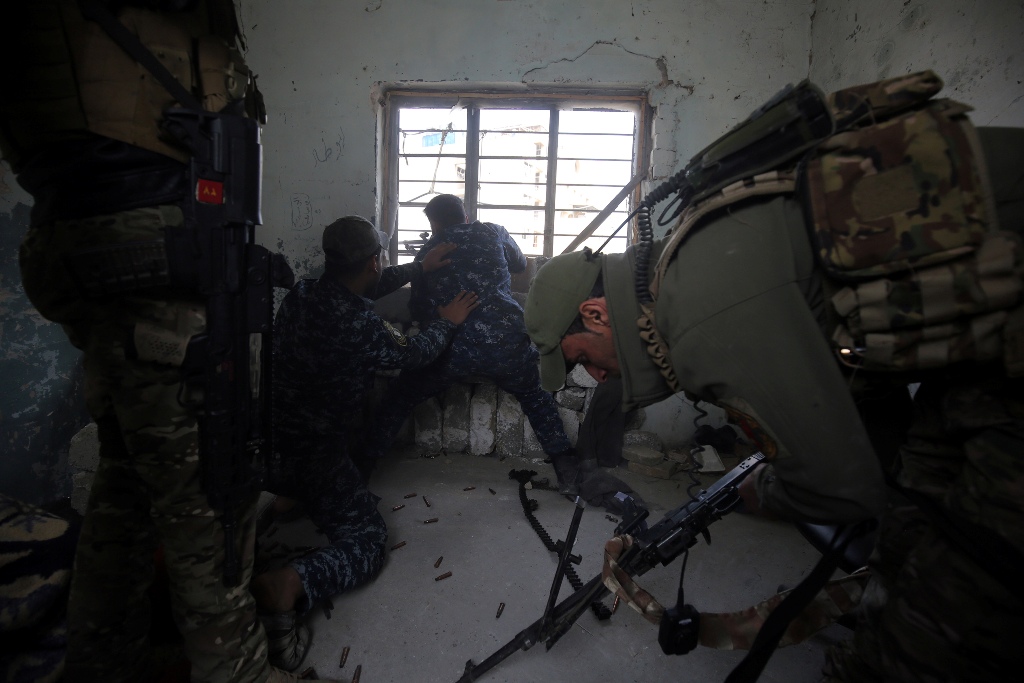 Iraqi forces, consisting of the Iraqi federal police and the elite Rapid Response Division, fires towards Islamic State (IS) group jihadists as they advance in the Old City in western Mosul on March 19, 2017, during the offensive to retake the city from I