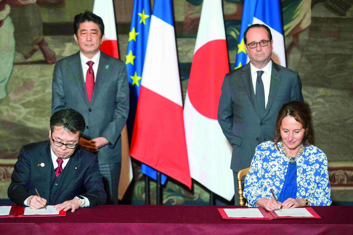 French Ecology Minister Segolene Royal (right) and Japanese Economy, Trading and Industry Minister Hiroshima Seko sign an agreement in front of French President Francois Hollande and Japanese Prime Minister Shinzo Abe at the Elysee Palace in Paris, France