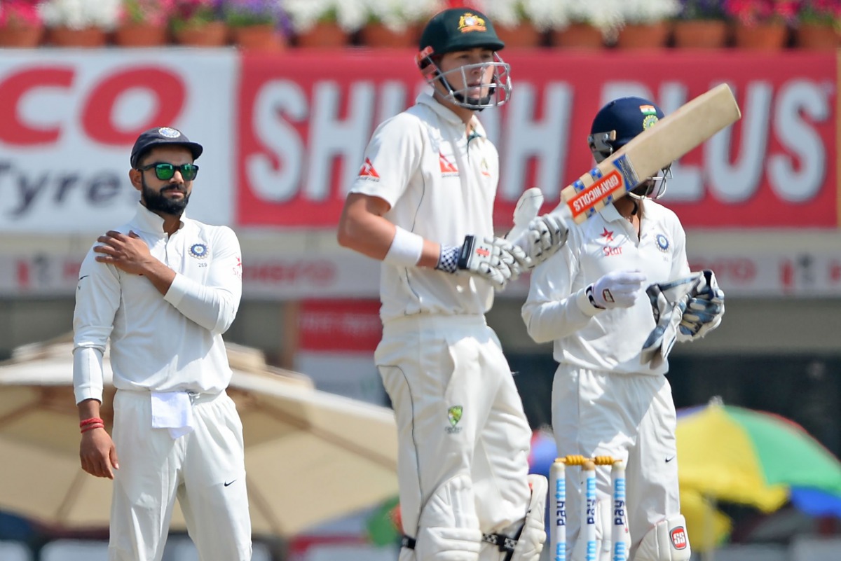 This file photograph taken on March 20, 2017, shows Indian captain Virat Kohli (L) as he touches his injured shoulder as Australian batsman Matthew Renshaw looks on during the fifth day of the third cricket Test match between India and Australia at the Jh