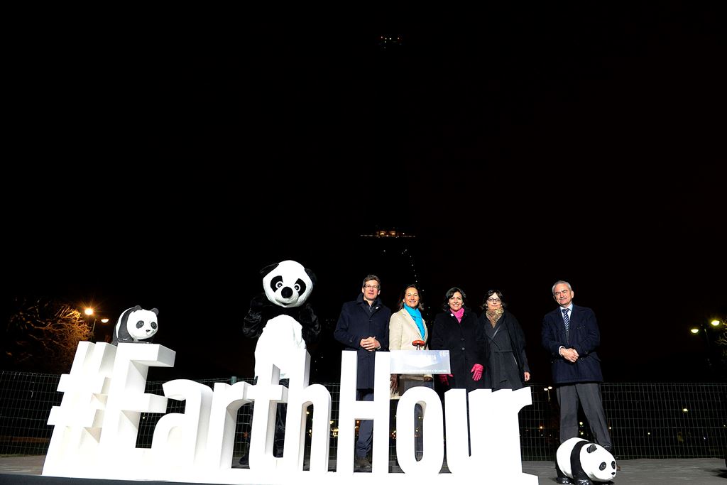 (L-R) WWF France president Pascal Canfin, French Ecology Minister Segolene Royal and Paris mayor Anne Hidalgo poses near the Eiffel Tower in Paris after it went dark for the Earth Hour environmental campaign on March 19, 2016. / AFP / THOMAS OLIVA