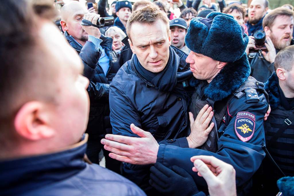 This handout picture taken and provided by Evgeny Feldman for Alexei Navalny's campaign on March 26, 2017 shows police officers detaining Kremlin critic Alexei Navalny during an unauthorised anti-corruption rally in central Moscow. AFP PHOTO / Evgeny Feld