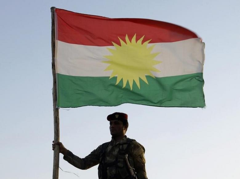 A Kurdish Peshmerga soldier holds a Kurdistan flag during a deployment in the area near the northern Iraqi border with Syria, which lies in an area disputed by Baghdad and the Kurdish region of Ninawa province, August 6, 2012. REUTERS/Azad Lashkari
