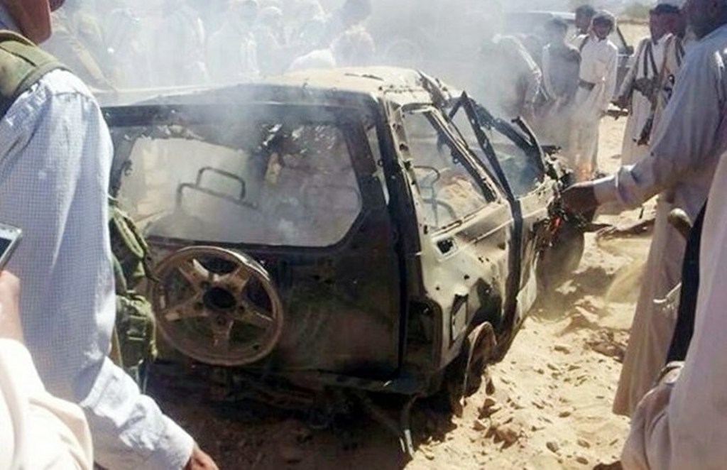 Yemenis gather around a burned car after it was targeted by a drone strike killing three suspected Al-Qaeda militants on Jan. 26, 2015 between the Marib and Chabwa provinces, a desert area east of Sanaa. AFP PHOTO / STR.