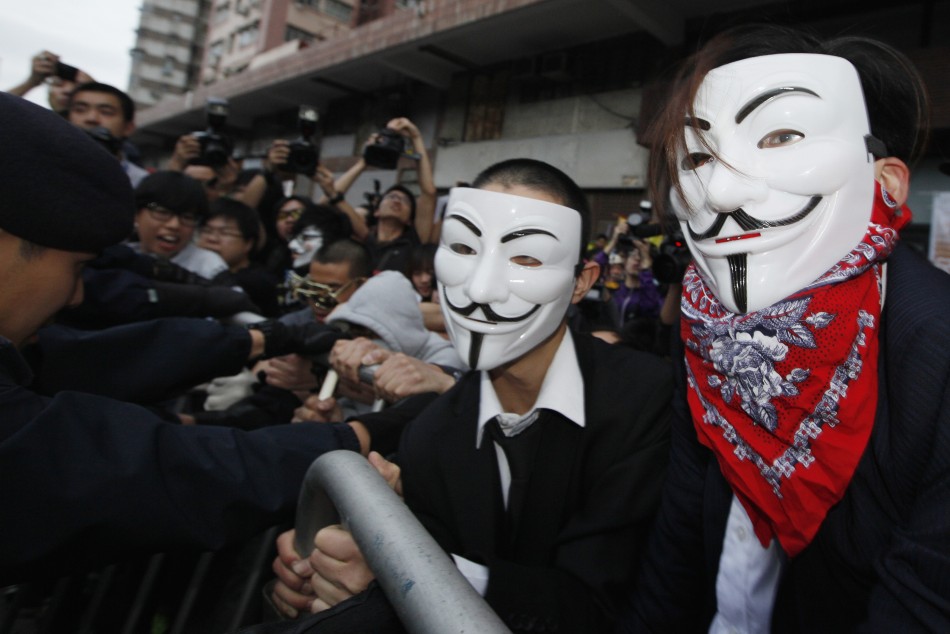 FILE PHOTO: Pro-democracy demonstrators wearing Anonymous masks, scuffle with police during a protest against the Chinese government's meddling into the Hong Kong's chief executive election, in Hong Kong April 1, 2012. REUTERS/Tyrone Siu