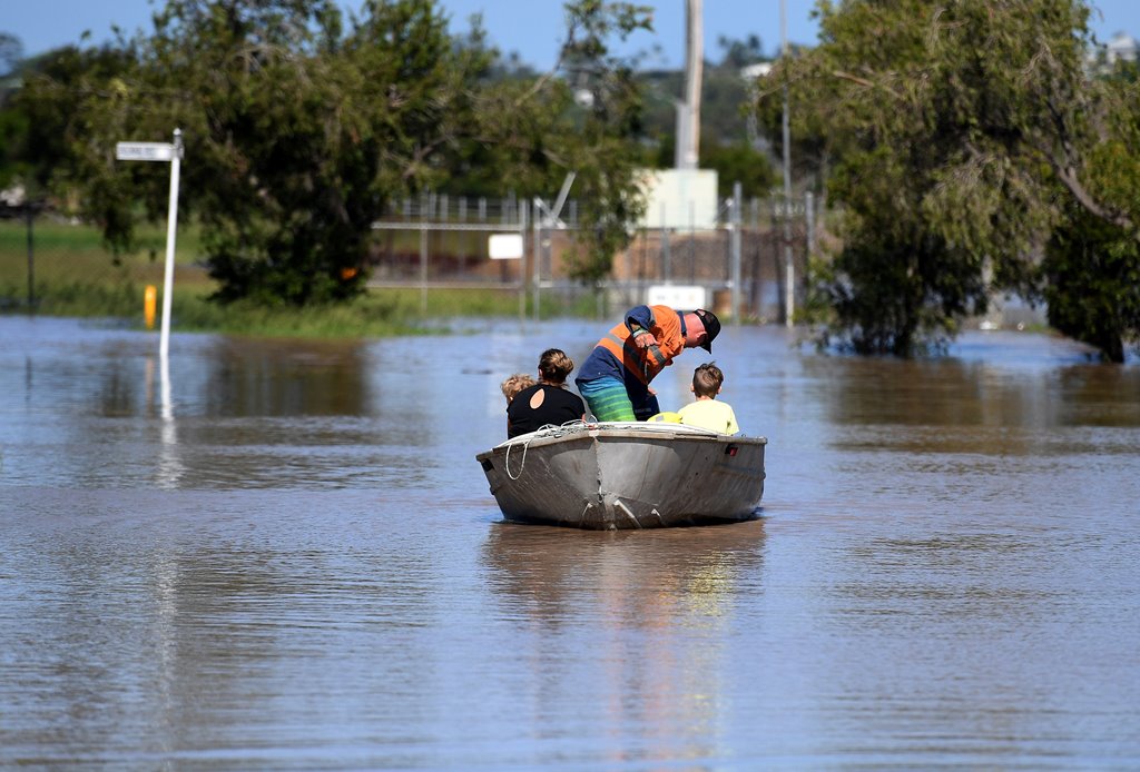A family uses a boat to get to their house through floodwaters created by Cyclone Debbie in Rockhampton, Australia, April 4, 2017. AAP/Dan Peled/via REUTERS