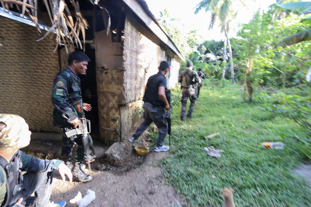 Police and soldiers take position as they engage with the Abu Sayyaf group in the village of Napo, Inabanga town, Bolo province, in the central Philippines on April 11, 2017.   AFP / STR
