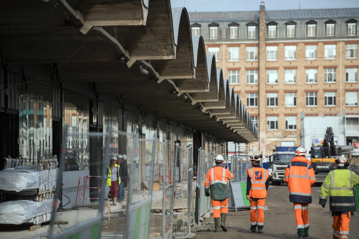 This file photo taken on October 18 2016 shows workers walking through the construction site of the world-biggest start-up incubator Station F, formerly known as the Halle Freyssinet in Paris (AFP / Lionel Bonav) 