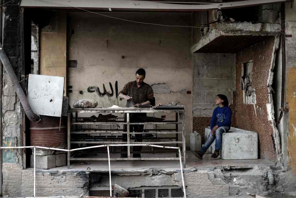 A Syrian man bakes a bread at his damaged bakery in the rebel-held town of Douma, on the eastern outskirts of the Syrian capital Damascus, on April 13, 2017. / AFP / Sameer Al-Doumy

