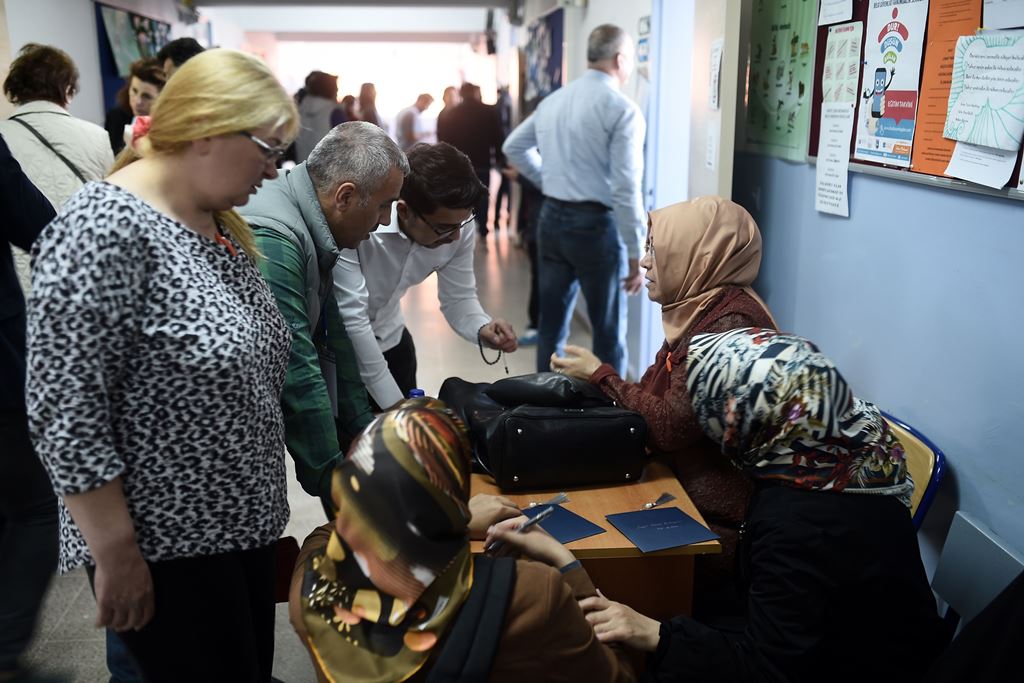 People and electoral officials are seen at a polling station as the country votes in the referendum on expanding the powers of the Turkish president on April 16, 2017 in Istanbul. AFP / OZAN KOSE