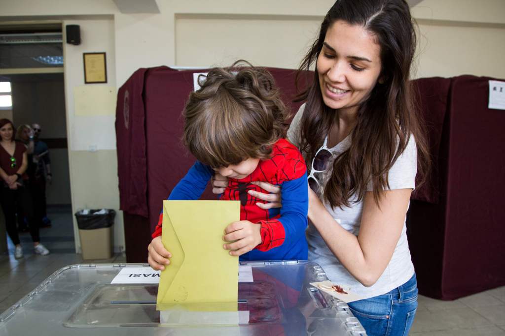 A little boy casts a ballot at a polling station during the referendum on expanding the powers of the Turkish president on April 16, 2017 in the Istanbul district of Besiktas.   AFP / HAKAN GOKTEPE
