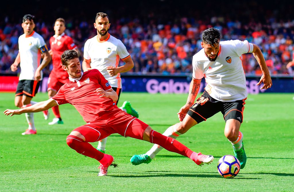 Sevilla's defender Sergio Escudero (L) vies with Valencia's Argentinian defender Ezequiel Garay during the Spanish league football match Valencia CF vs Sevilla FC at the Mestalla stadium in Valencia on April 16, 2017. / AFP / JOSE JORDAN
