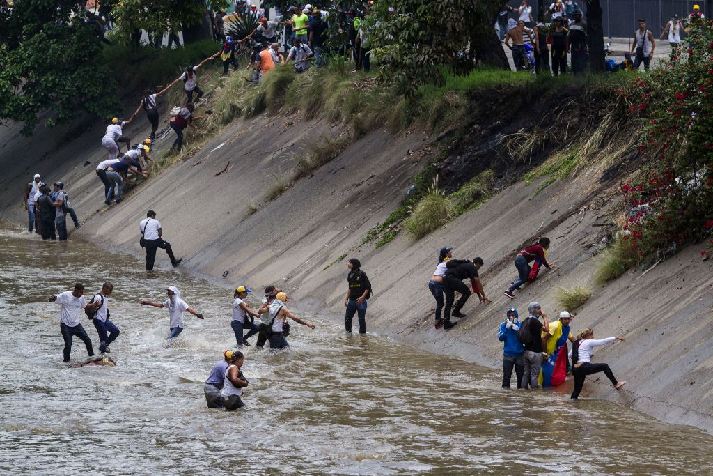 Demonstrators flee after riot police clash with protesters taking part in a rally against Venezuelan President Nicolas Maduro, in Caracas on April 19, 2017.  AFP / Leo Alvarez
