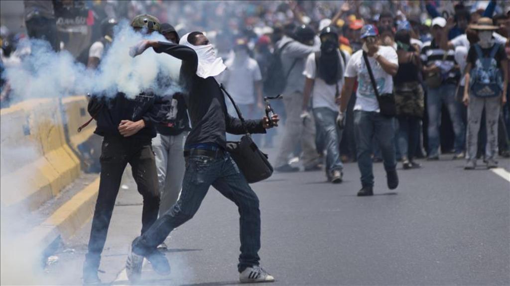 Venezuelan opposition activists throwing back a tear gas canister during clashes with the police in Caracas, Venezuela on April 10, 2017. The center-right opposition vowed fresh street protests -after earlier unrest left dozens of people injured - to incr