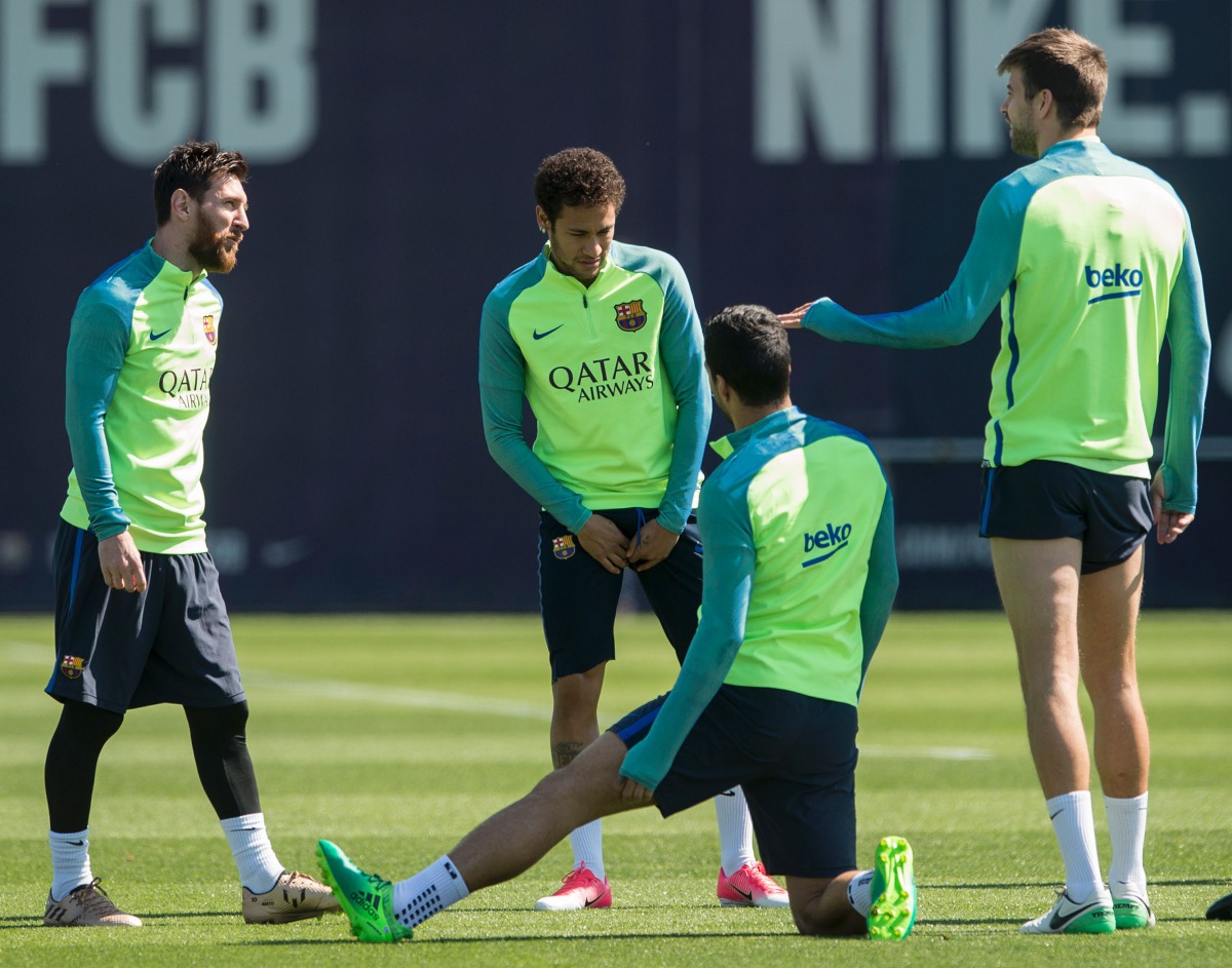 Barcelona's Argentinian forward Lionel Messi (L) chats with Barcelona's Brazilian forward Neymar (2ndL) and Barcelona's defender Gerard Pique (R) during a training session at the Sports Center FC Barcelona Joan Gamper in Sant Joan Despi, near Barcelona on