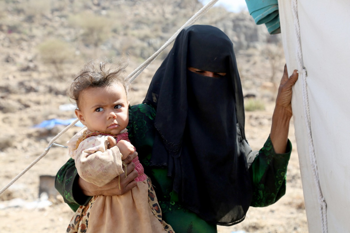 FILE PHOTO: A woman holds a child near the Mocha port on the Red Sea in Taiz, Yemen on March 1, 2017 (Abdulnasser Alseddik / Anadolu Agency) 