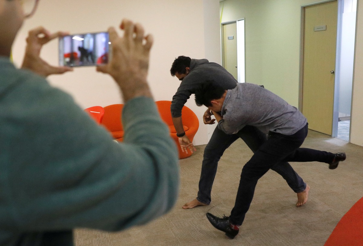 Graymatics employees pretend to fight as they record footage to be used to 