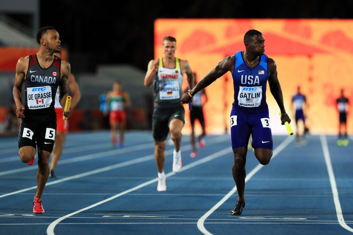 (FILES) This file photo taken on April 22, 2017 shows Andre De Grasse of Canada and Justin Gatlin of the USA running to the finishline in heat two of the Men's 4 x 100 Meters Relay during the IAAF/BTC World Relays Bahamas 2017 at Thomas Robinson Stadium i