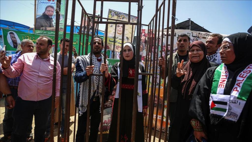 Gazaian Said Lulu (C-R) and Halud Dervis (C-L) stand behind a symbolic jail during their wedding ceremony at the tent, which is established for solidarity with hunger-striker prisoners at Israeli prisons at Saraya Square in Gaza City, Gaza on May 8, 2017.