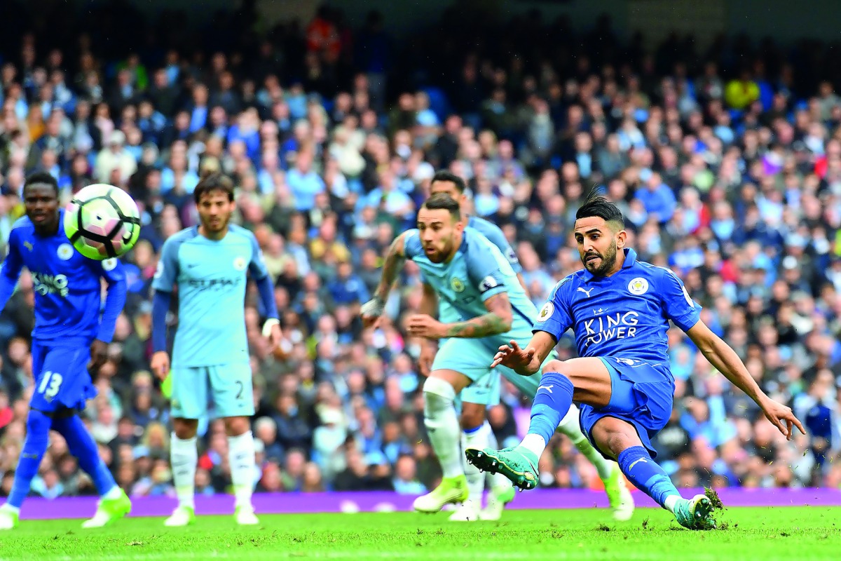 Leicester City's midfielder Riyad Mahrez (right) slips after taking his penalty, which hit his standing foot on the way to the goal, and was subsequently disallowed during the English Premier League match against Manchester City at the Etihad Stadium in M