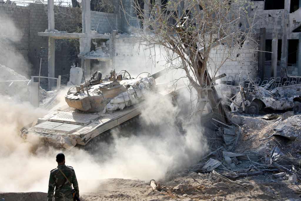 Syrian pro-government forces manoeuver a tank as they advance through Qabun district, on the outskirts of the capital Damascus, on May 13, 2017, during an offensive to retake the area from opposition fighters. / AFP / STRINGER
