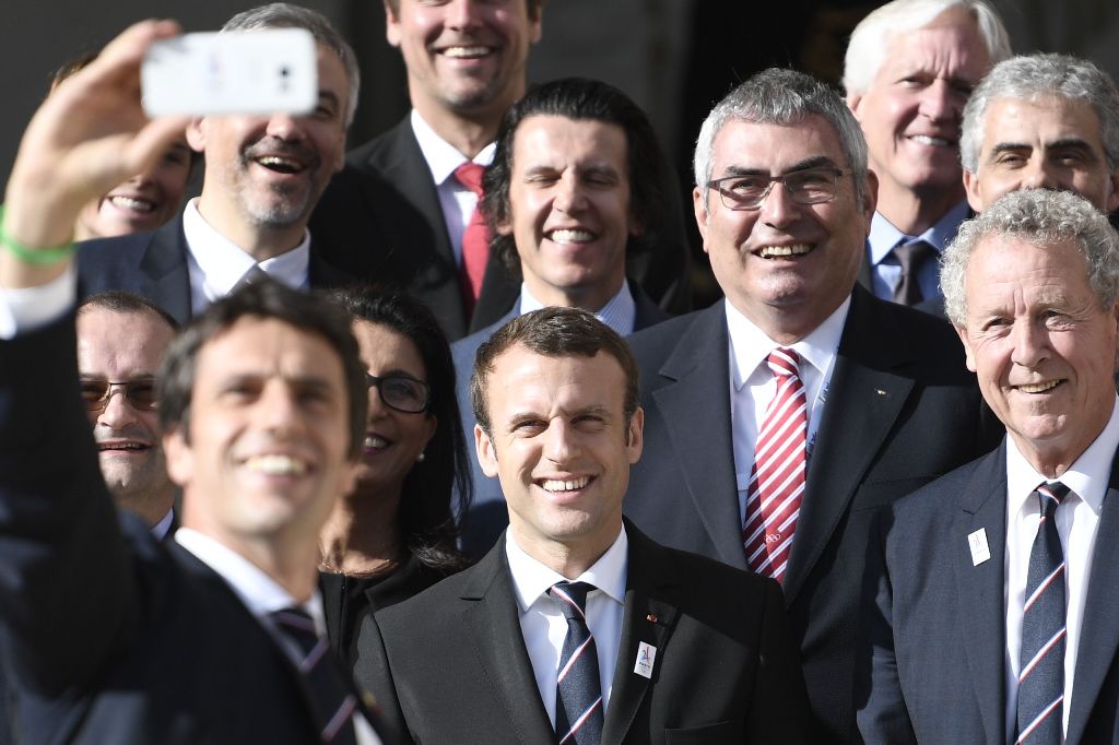 The co-president of the Paris bid for the 2024 Olympics Tony Estanguet (L, foreground) takes a selfie with new French President Emmanuel Macron (C), the president of the IOC Evaluation Commission for the 2024 Olympics Patrick Baumann (L) and French member