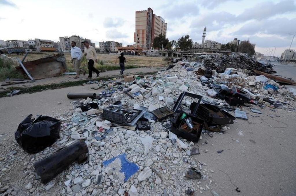 People walk near rubble inside Waer district, after rebel fighters and their families evacuated the besieged Waer district in the central Syrian city of Homs, after an agreement was reached between rebels and Syria's army, Syria May 21, 2017. REUTERS/Omar
