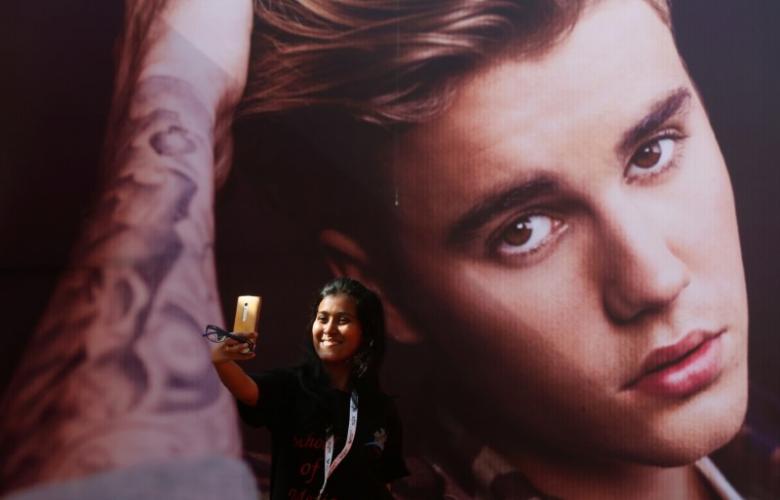 A girl takes a selfie in front of a hoarding outside the venue of Canadian singer Justin Bieber concert in Mumbai, India May 10, 2017. REUTERS/Shailesh Andrade
