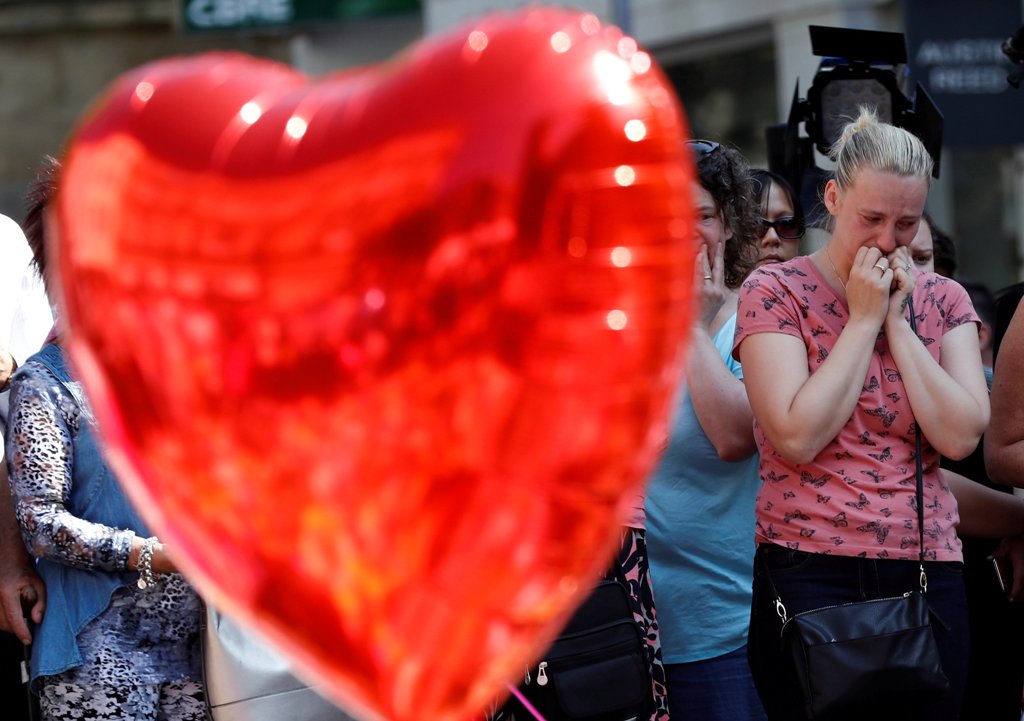 A woman reacts before a minute of silence for the victims of the Manchester Arena attack, in St Ann's Square, in central Manchester, Britain May 25, 2017. REUTERS/Stefan Wermuth
