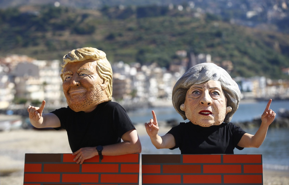 Protesters wear masks depicting U.S. President Donald Trump and Britain's Prime Minister Theresa May during a demonstration against a G7 summit organised by Oxfam in Giardini Naxos near Taormina, Sicily, Italy, May 27, 2017. (REUTERS/Yara Nardi)