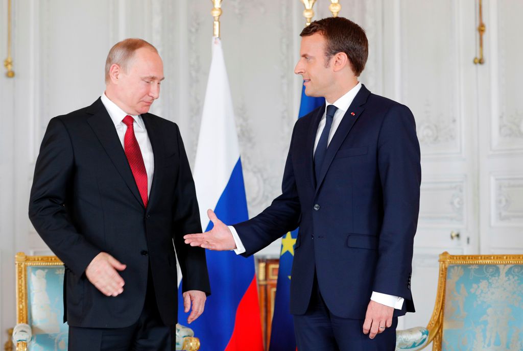 French President Emmanuel Macron (R) shakes hands with Russian President Vladimir Putin (L) at the Chateau de Versailles as they meet for talks in Versailles on May 29, 2017.  AFP / PHILIPPE WOJAZER
