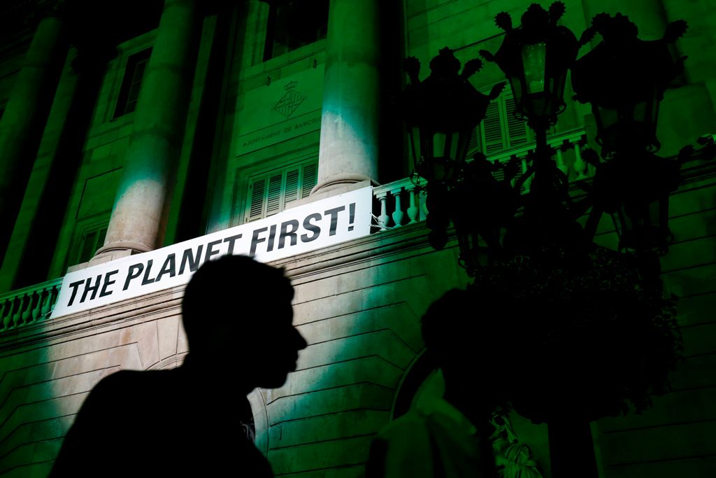 A picture taken on June 2, 2017, shows the City Hall of Barcelona illuminated in green to protest against the announcement by US President Donald Trump on their decision to take the United States out of the Paris climate accord, pledging to meet greenhous