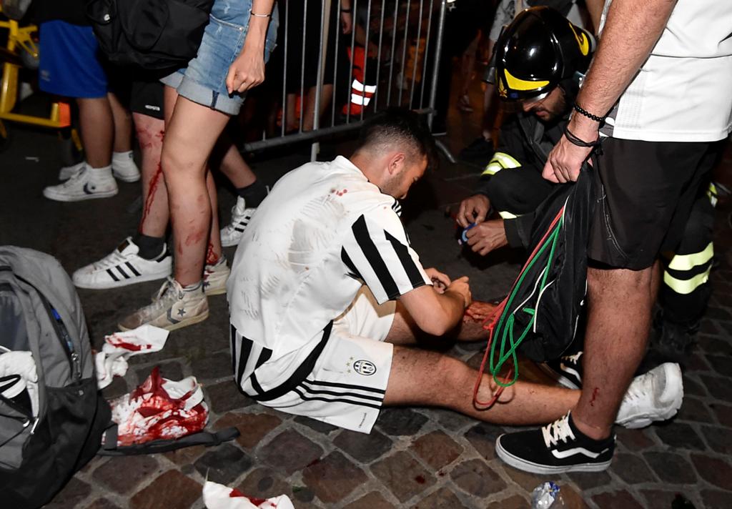  June 3, 2017 A Juventus' fan receives first aids as the fans gathered in San Carlo Square run away following panic created by the explosion of firecrackers as they was watching the match on a giant screen. REUTERS/Giorgio Perottino
