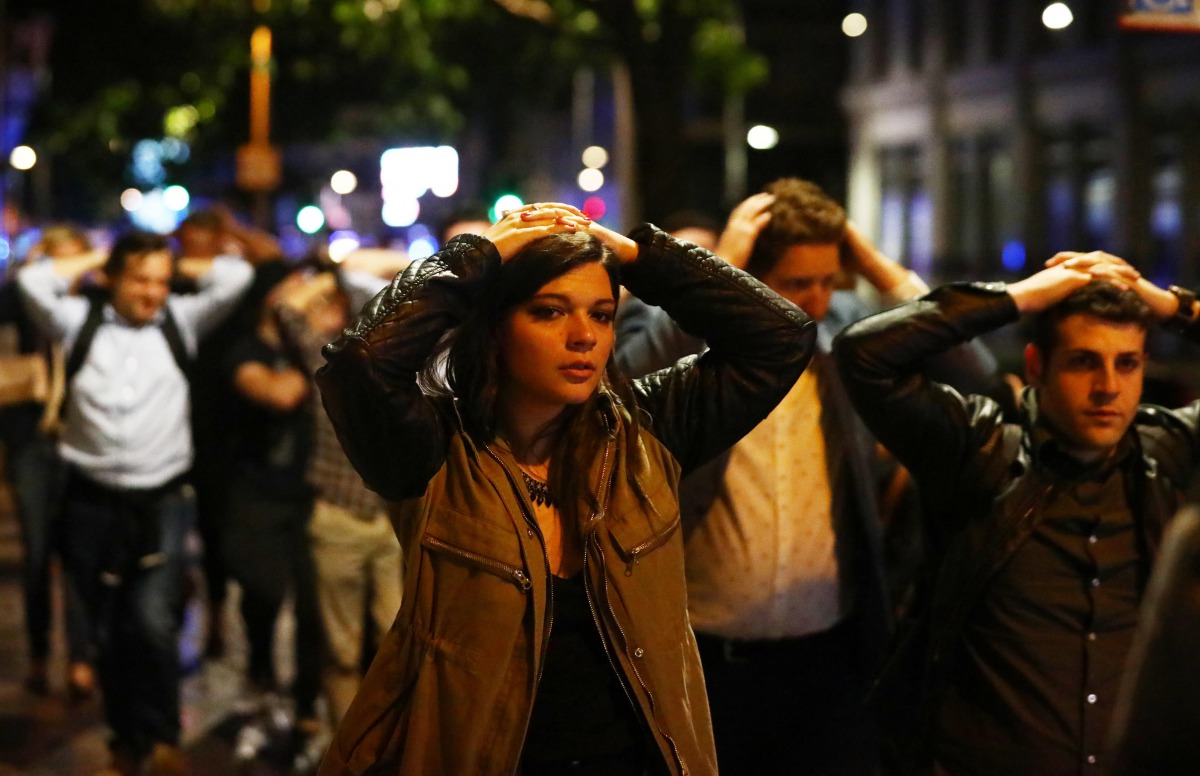 People leave the area with their hands up after an incident near London Bridge in London, Britain June 4, 2017. (REUTERS/Neil Hall)