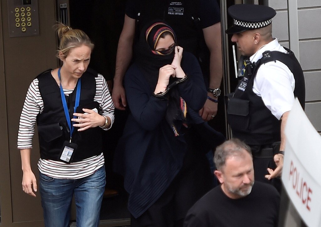Police officers escort a woman to a police van after raiding a block of flats in Barking, east London, Britain, June 4, 2017. REUTERS/Hannah McKay

