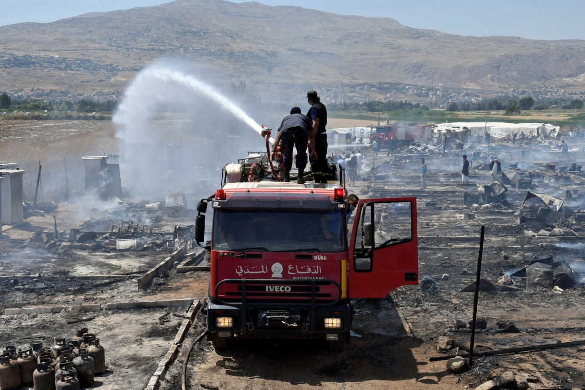 Civil defence members put out fire at a camp for Syrian refugees near the town of Qab Elias, in Lebanon's Bekaa Valley, July 2, 2017. (REUTERS/Hassan Abdallah)