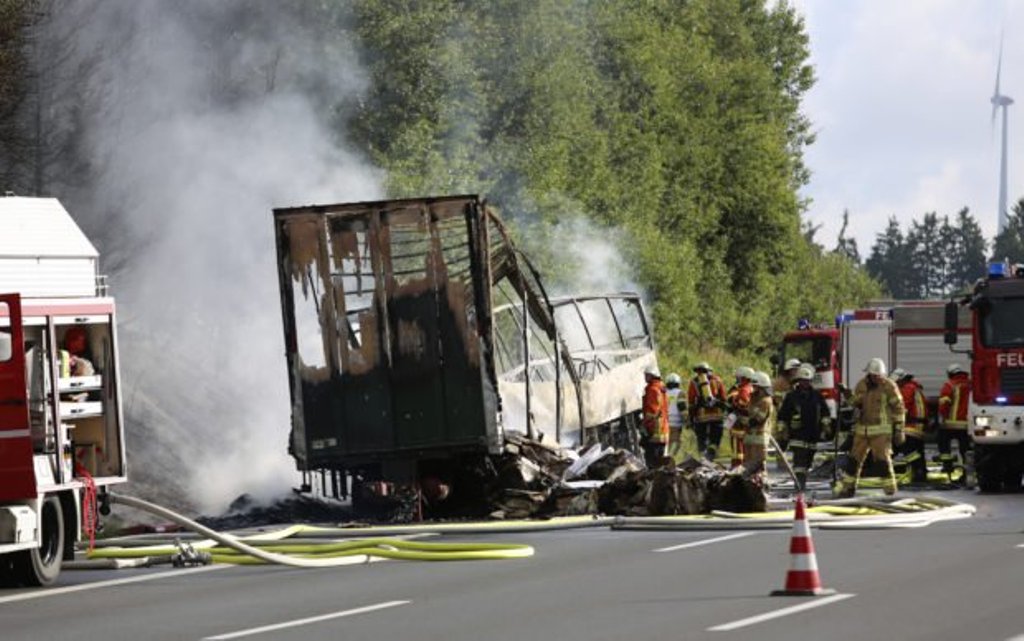 Firefighters work at the scene where a tour bus burst into flames following a collision with a trailer truck on the highway A9 near Münchberg, southern Germany, on July 3, 2017, where up to 17 people are feared dead. AFP.