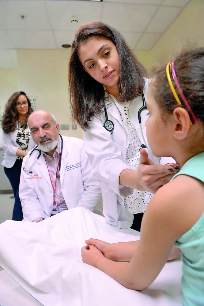 A nedical student at WCM-Q examines a child during the Cornell Stars event.