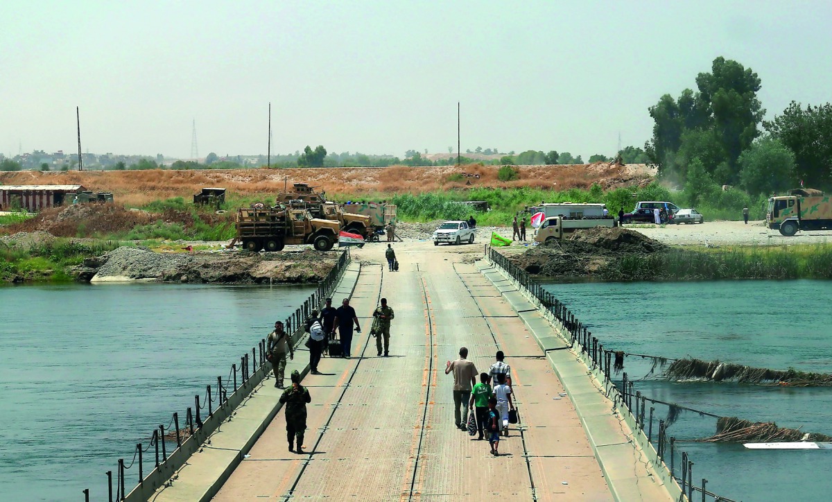 Iraqis cross a bridge connecting west and east Mosul, yesterday, a few days after the government's announcement of the 